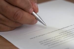 Close up of man signing document